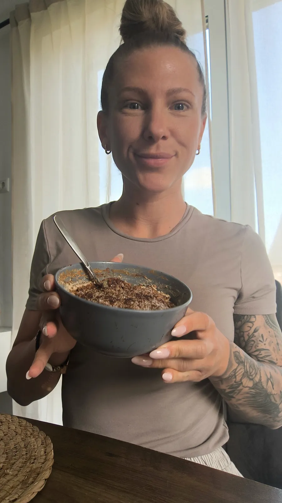 Helen hält lächelnd eine Frühstücksschale mit Skyr und Haferflocken